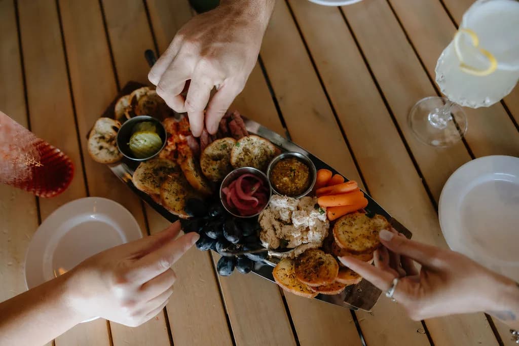 overhead-hands-sharing-charcuterie-board.jpg